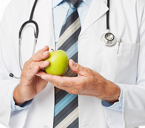 Gastroenterólogo en Bogotá sosteniendo manzana
