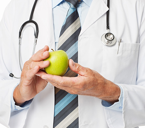 Mejore la alimentación de su bebé con un gastroenterólogo en Bogotá Gastroenterólogo en Bogotá sosteniendo manzana